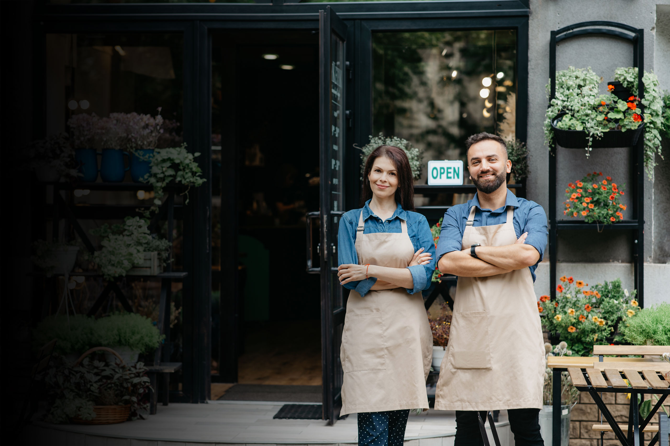 Two small-business owners standing outside their shop