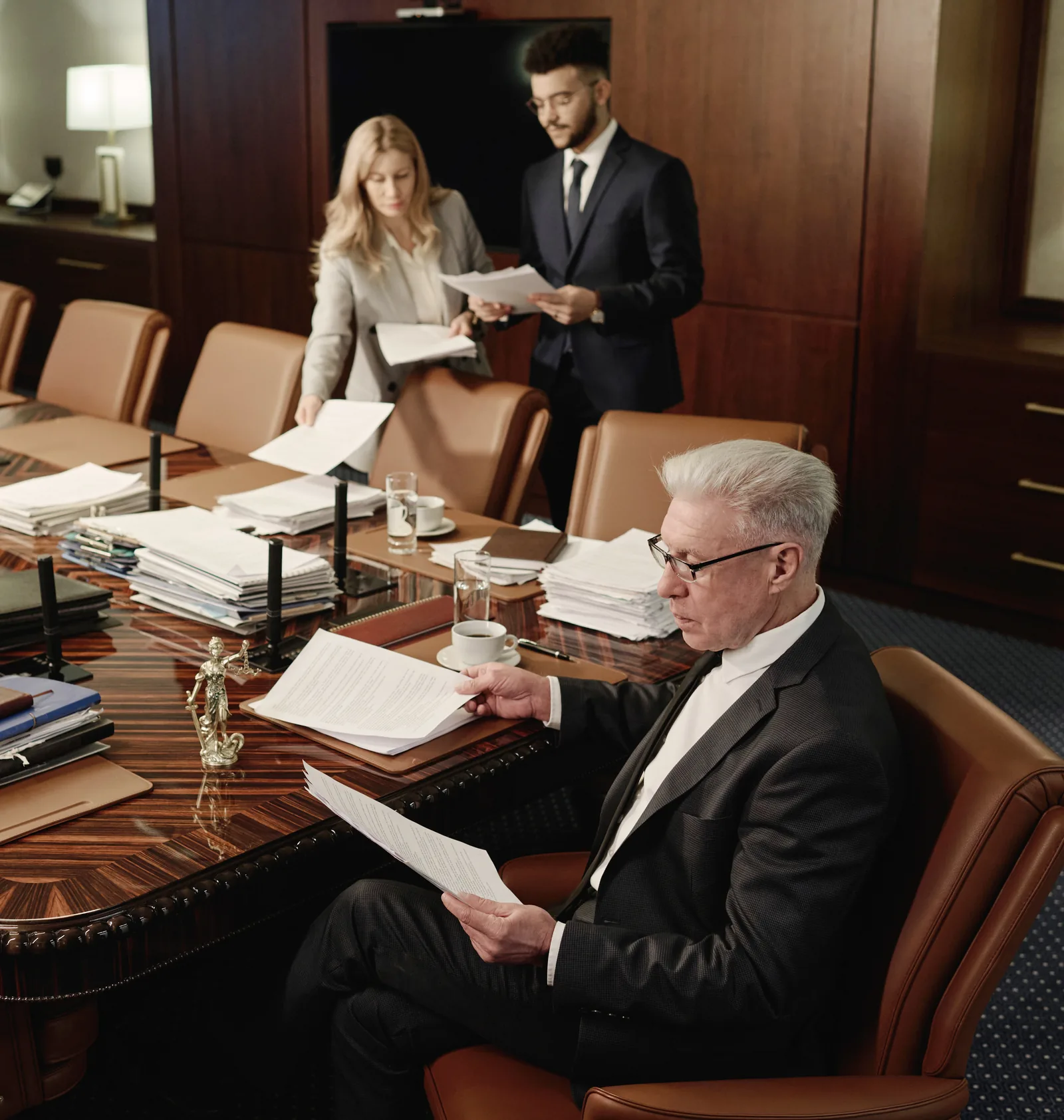 A senior attorney reviewing documents in a law firm conference room