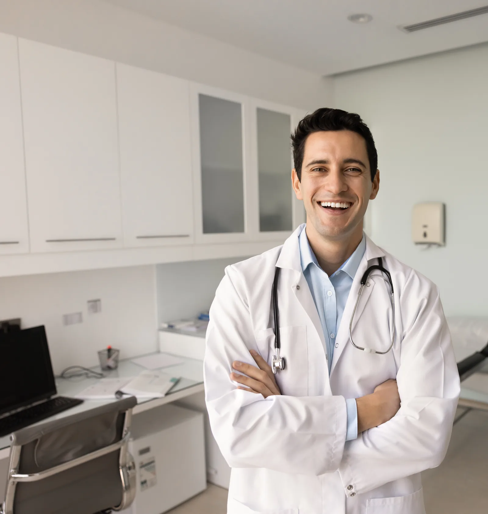 A physician smiling in a medical exam room